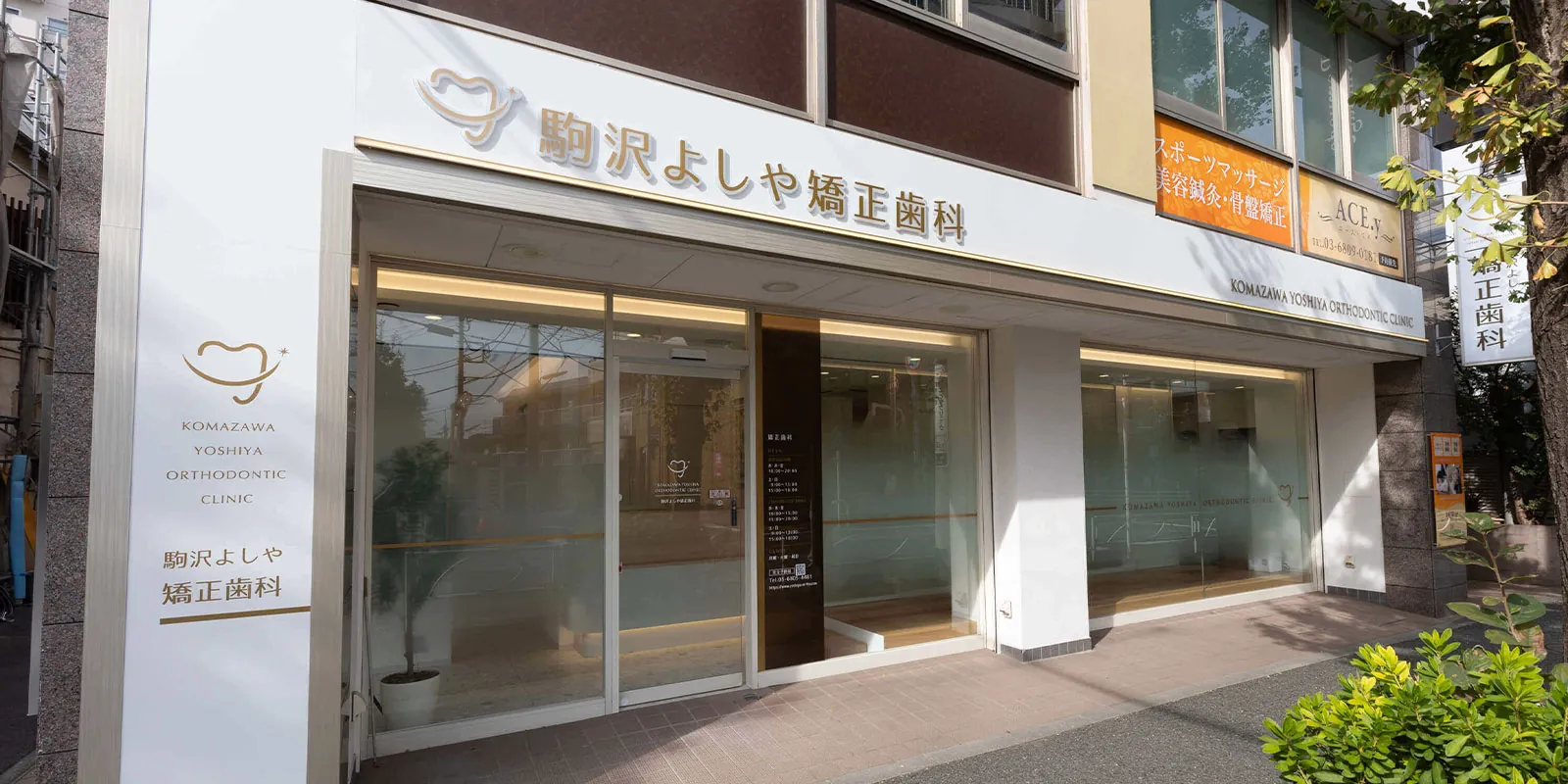 駒沢よしや矯正歯科の外観（1階ガラス張りの入口と看板）