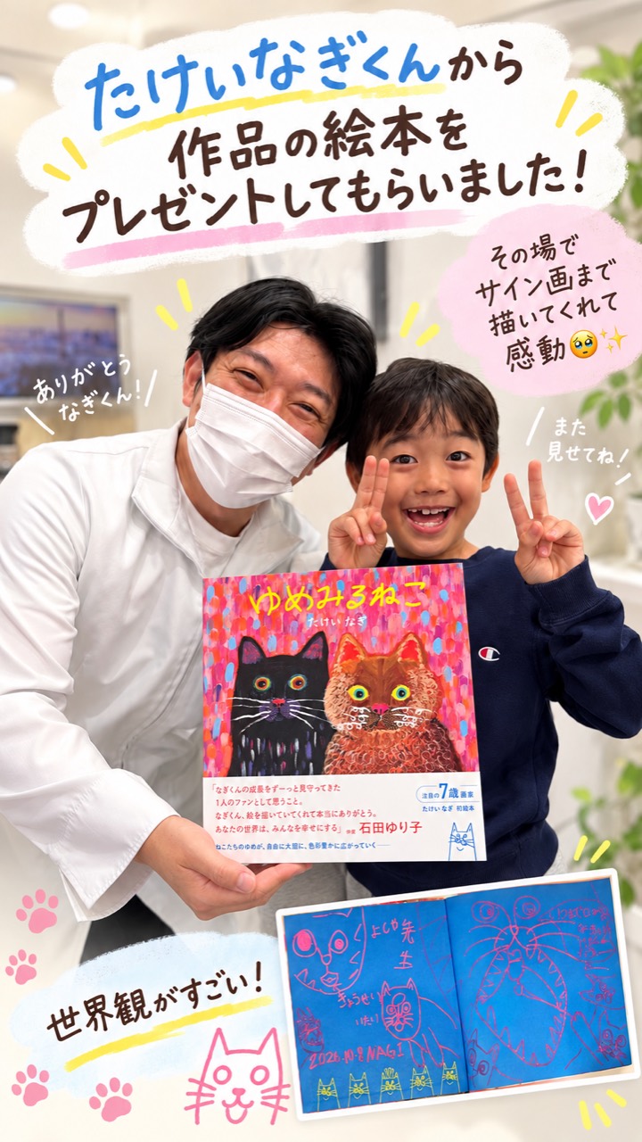 絵本『ゆめみるねこ』とサイン画を紹介する、たけいなぎくんと院長の記念写真